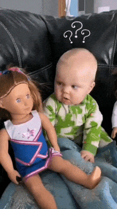 Baby looks at doll