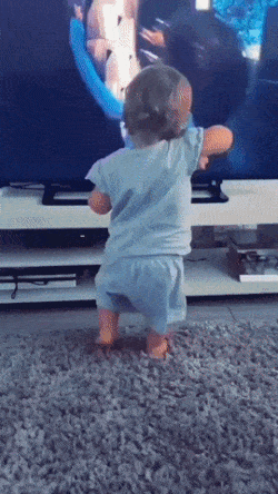 Baby is dancing in front of TV