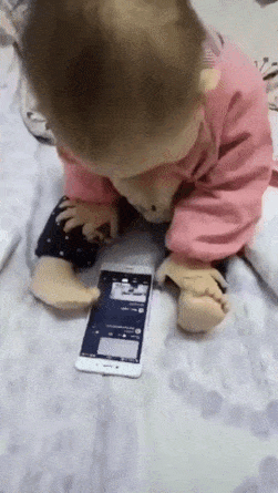 Baby scrolls phone with foot