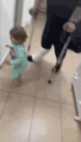 Baby helps dad with crutches