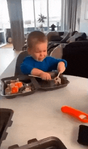 Boy eats sushi with sticks
