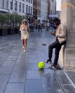 Girl kicks ball on street