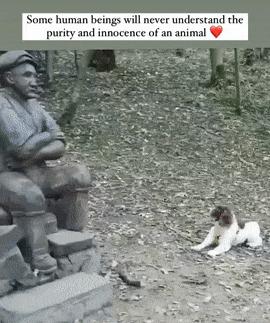 Dog reaches stick to sculpted man