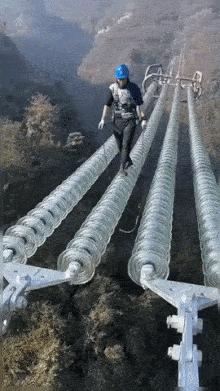 Power line worker walks on wire